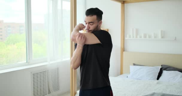 Мужчина растягивается и разогревается для тренировки в спальне — стоковое видео