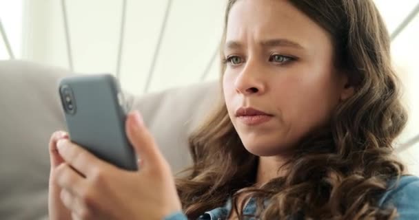 Vrouw sms 'en op mobiele telefoon zittend op luxe stoel — Stockvideo