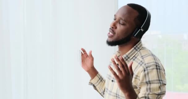 Mann singt, während er Musik über Kopfhörer hört — Stockvideo