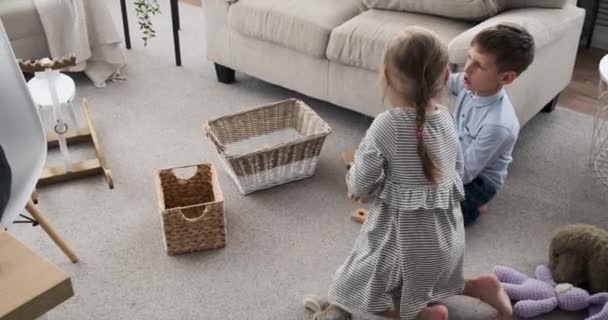 Moeder werken met behulp van laptop terwijl kinderen spelen met speelgoed blokken — Stockvideo
