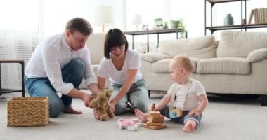 Ebeveynler evde erkek bebekle eğleniyor.