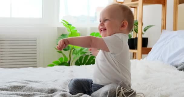 Baby jongen hebben plezier op bed — Stockvideo