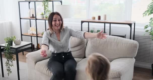 Mother greeting and embracing children holding drawing paper — Stock Video