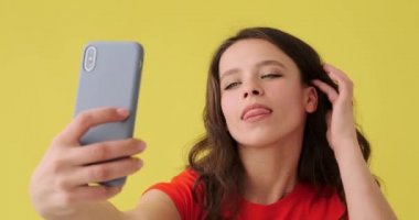 Güzel bir kadın cep telefonundan selfie çekiyor.