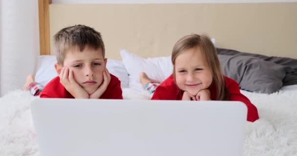 Kinder sehen Film mit Laptop auf dem Bett — Stockvideo