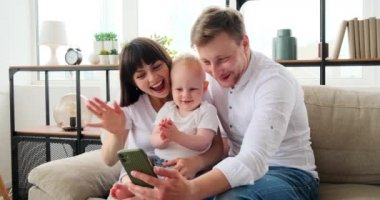 Mutlu aile cep telefonuyla video görüşmesi yapıyor.