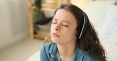 Güzel bir kadın kulaklıkla müzik dinliyor.