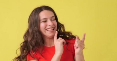 Sarı arka planda dans eden mutlu kadın