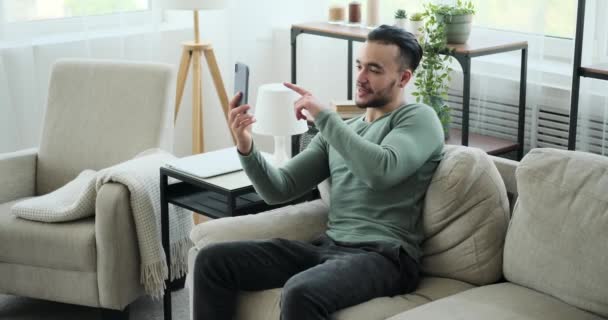 Молодий чоловік спілкується відео на мобільному телефоні — стокове відео