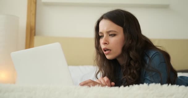 침대에서 노트북을 사용 하 여 행복 한 젊은 여자 — 비디오
