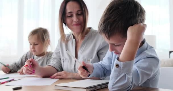 Мати допомагає дітям з домашнім завданням — стокове відео