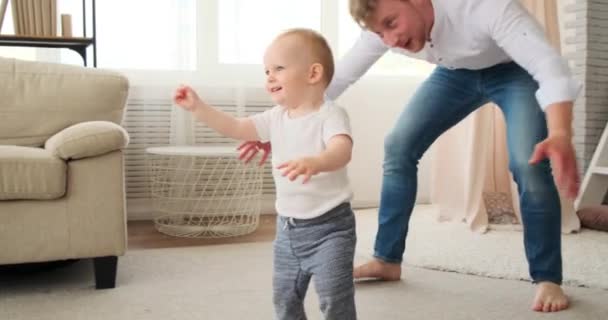 Pai brincando com o bebê filho caminhando em direção à mãe — Vídeo de Stock