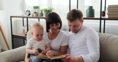 Anne ve baba, bebek için hikaye okuyorlar. 