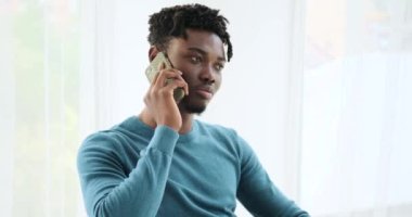 Cep telefonuyla konuşan Afrikalı Amerikalı bir adam.