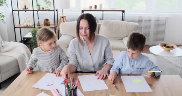 Mutter mit Kindern malt zu Hause auf Papier — Stockvideo