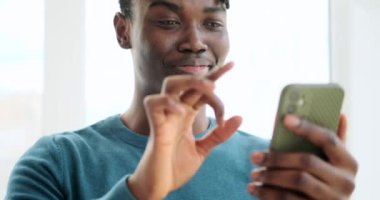 Neşeli adam cep telefonu kullanarak mesaj atıyor ya da komik mesajlar okuyor