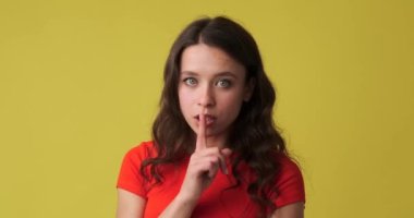 Dudaklarında parmaklarıyla mutlu bir kadın.