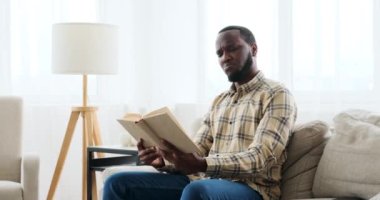 Kanepede kitap okuyan adam.