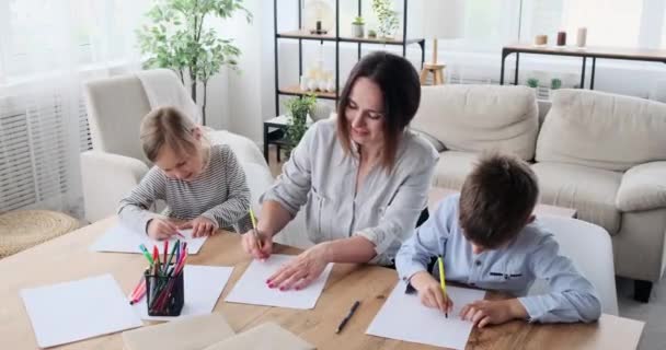 Madre con hijos dibujando sobre papel en casa — Vídeos de Stock