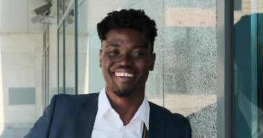 İş adamı ofis binasının önünde gülümsüyor