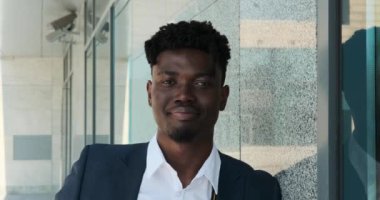 İş adamı ofis binasının önünde gülümsüyor