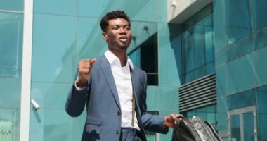 Neşeli iş adamı dans ediyor ve ofis çantası taşıyor.