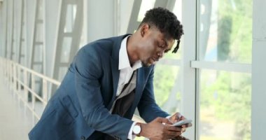 Havaalanında cep telefonu kullanan bir iş adamı.