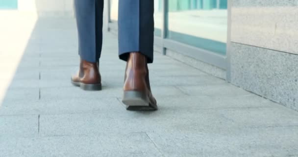 Бизнесмен, выходящий из офисного здания — стоковое видео