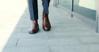 İş adamı ofis binasının önünde yürüyor