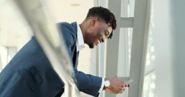 Havaalanında cep telefonu kullanan mutlu iş adamı mesajı