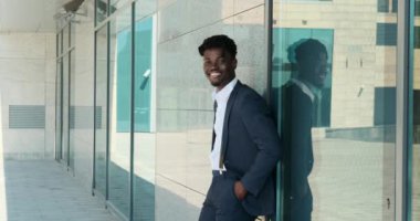 Ofis binasının dışında gülümseyen kendine güvenen işadamı