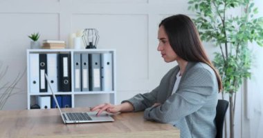 İş kadını ofisteki laptopuyla olumlu haberler alıyor