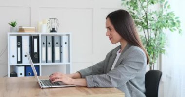 İş kadını ofisteki bilgisayarı kullanarak online başarıyı kutluyor