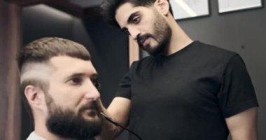 Berber saç ve tarak makası kullanarak saç kesiyor.