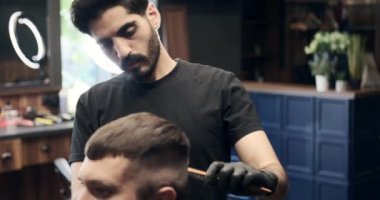 Berber kuaförde saç kesiyor.