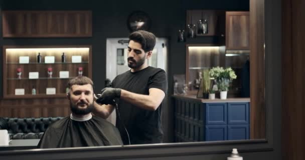 Barber cutting hair using trimmer — Stock Video