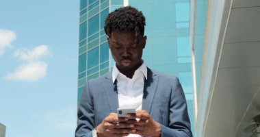 İş adamı ofis binasının dışında cep telefonu kullanıyor.