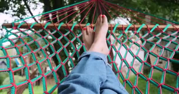 Beine der Frau entspannen, während sie auf der Hängematte liegen — Stockvideo