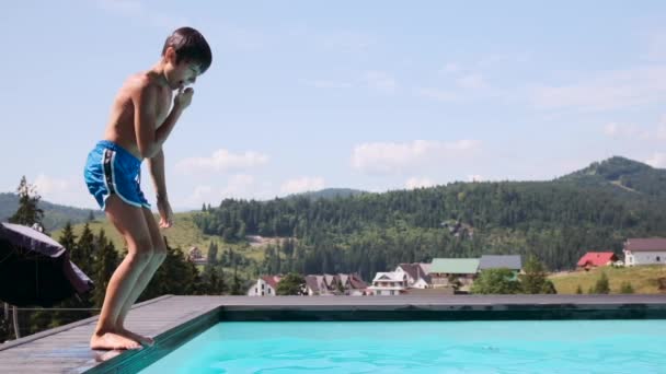 Szczęśliwy chłopiec skacze do basenu — Wideo stockowe