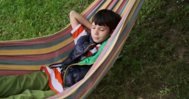 Fáradt fiú alszik függőágyon — Stock videók