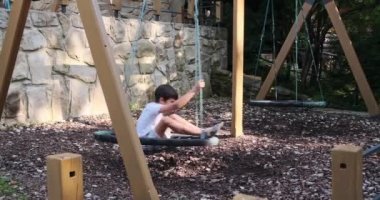 Çocuk yuvarlak salıncakta oynuyor