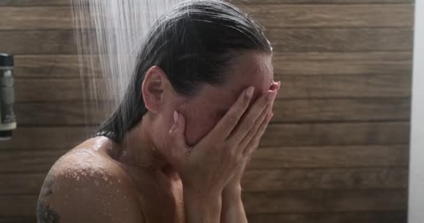 Mladá žena skrývá tvář s rukama a pláč při sprchování — Stock video