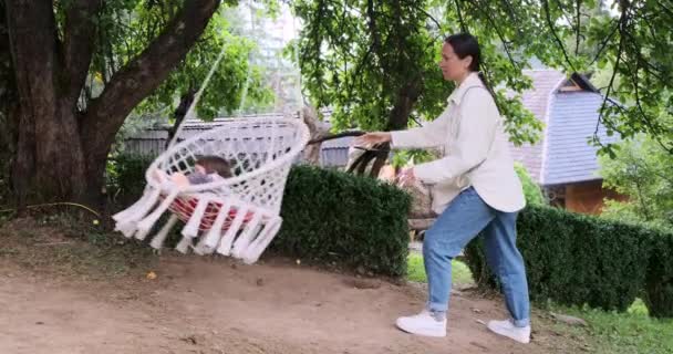 Madre spingendo sua figlia su swing — Video Stock