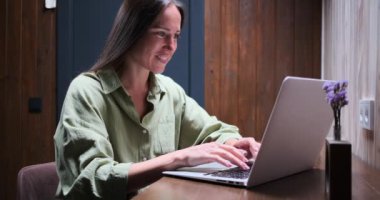 Gece geç saatte dizüstü bilgisayar kullanan mutlu kadın.