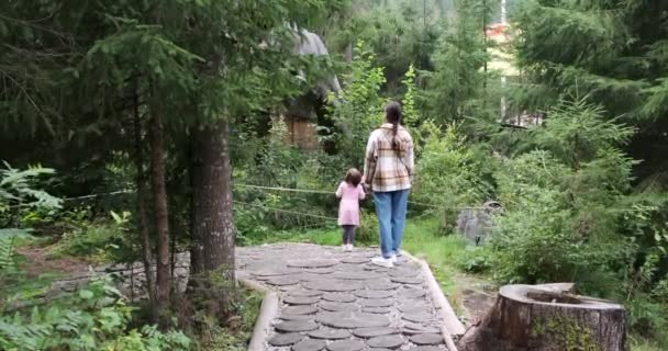 Kvinna med dotter beundrar naturen och springer på stigen i skogen — Stockvideo