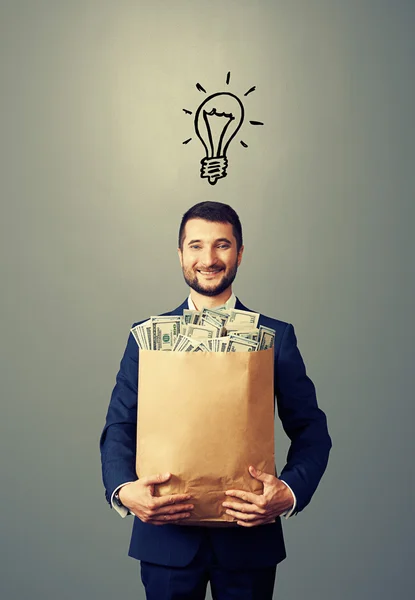 Man with bulb and money — Stock Photo, Image