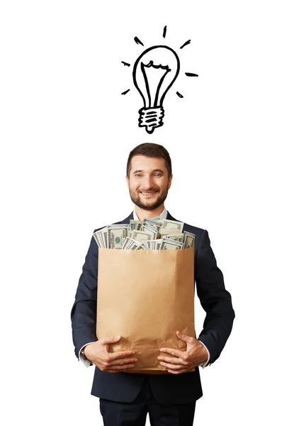 Man with light bulb and money — Stock Photo, Image