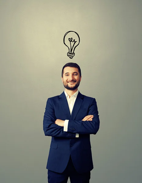 Smiley businessman with drawing light bulb — Stock Photo, Image