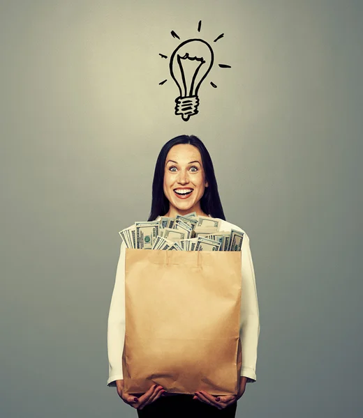 Woman with light bulb and money — Stock Photo, Image