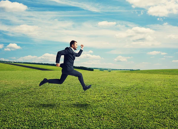 Smiley businessman in suit running fast — Stock Photo, Image